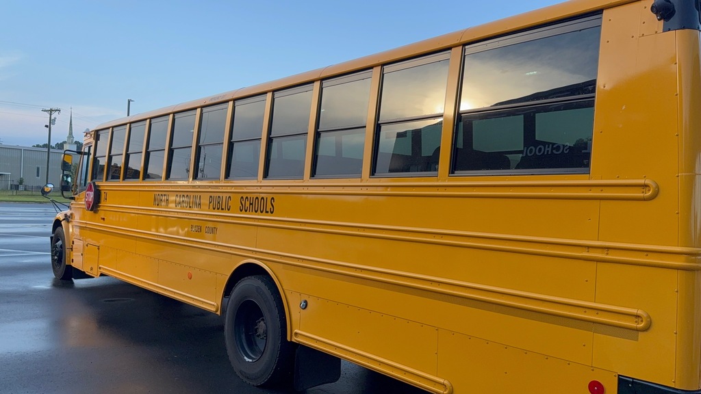 A yellow school bus sits in the parking lot. 