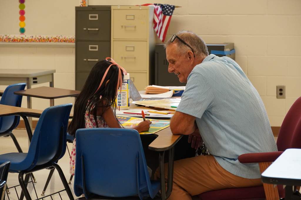 A teacher works one on one with an elementary aged student.