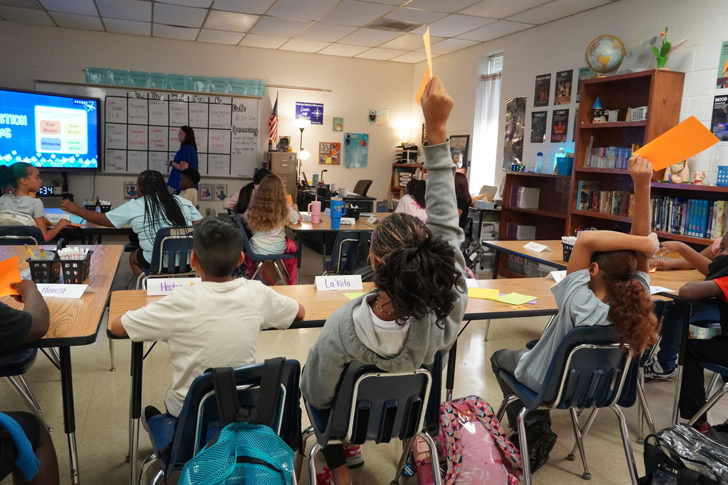 A student raises their hand to answer a question. 