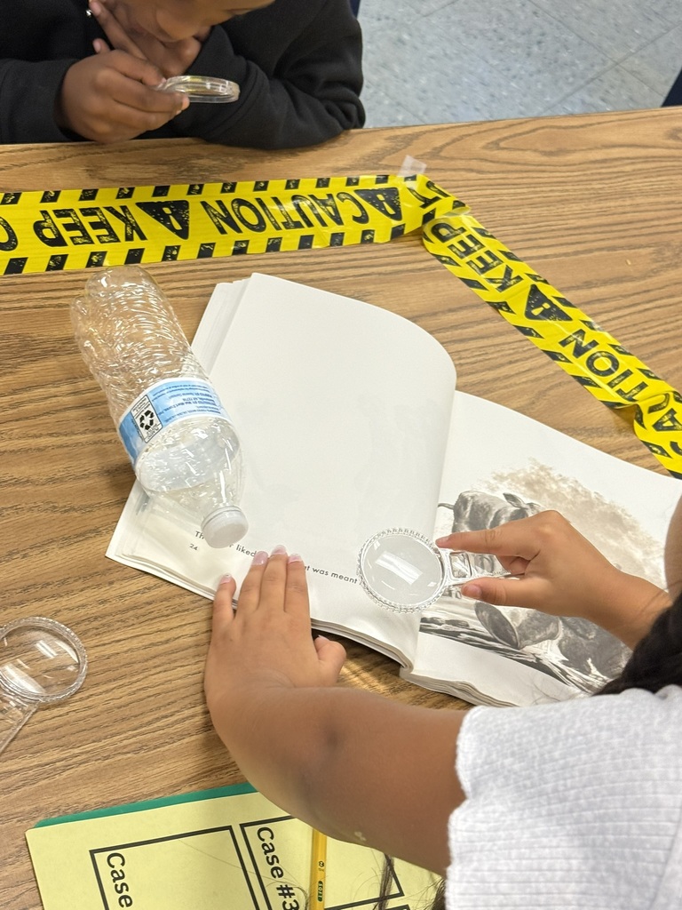 Students work together as library detectives, examining a book and recording clues.