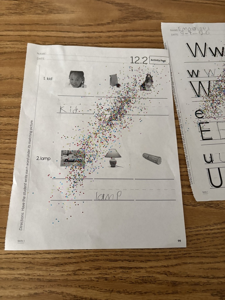 Student worksheet showing careful handwriting practice with colorful fairy dust sprinkled across the page.