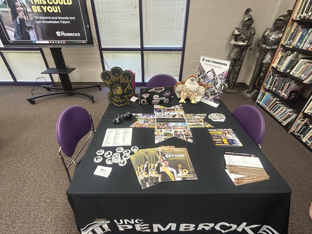 UNC Pembroke admissions table displaying brochures, informational materials, and UNCP merchandise.