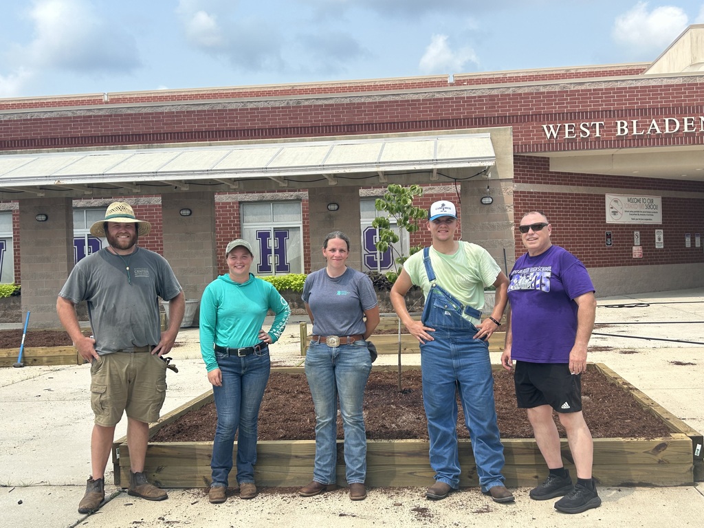 People standing in front of completed garden beds.