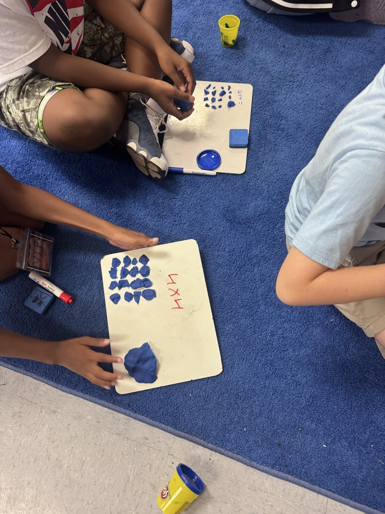 Students use colorful Play-Doh on dry-erase boards to create arrays and equal groups while practicing multiplication facts.