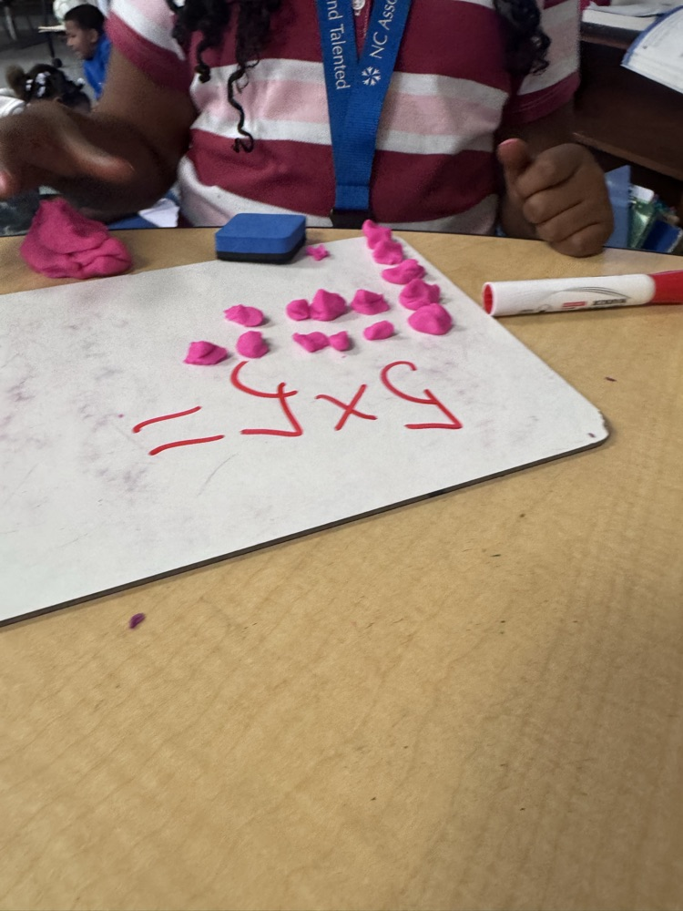 Students use colorful Play-Doh on dry-erase boards to create arrays and equal groups while practicing multiplication facts.