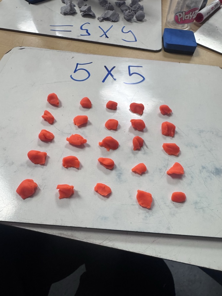 Students use colorful Play-Doh on dry-erase boards to create arrays and equal groups while practicing multiplication facts.