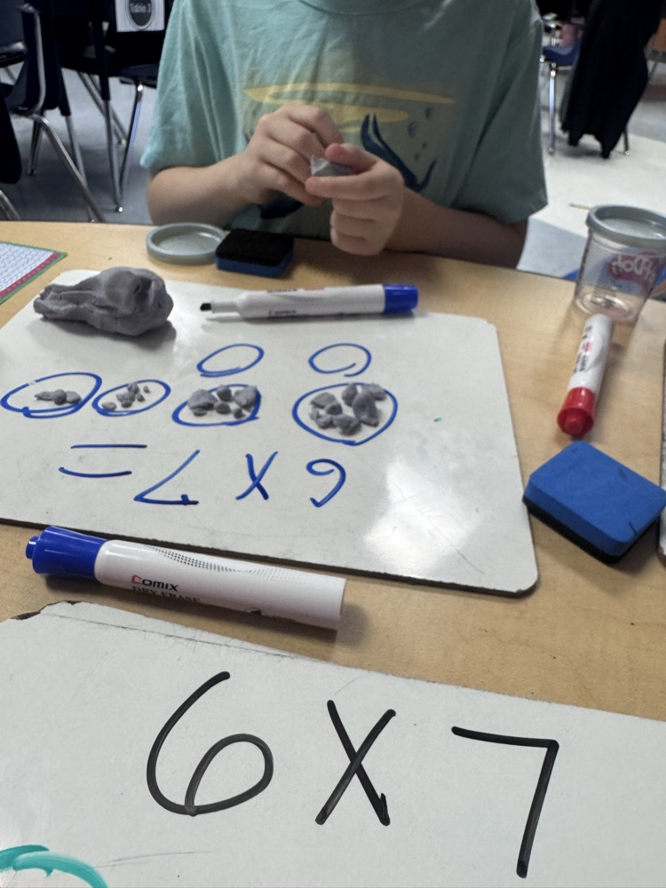 Students use colorful Play-Doh on dry-erase boards to create arrays and equal groups while practicing multiplication facts.