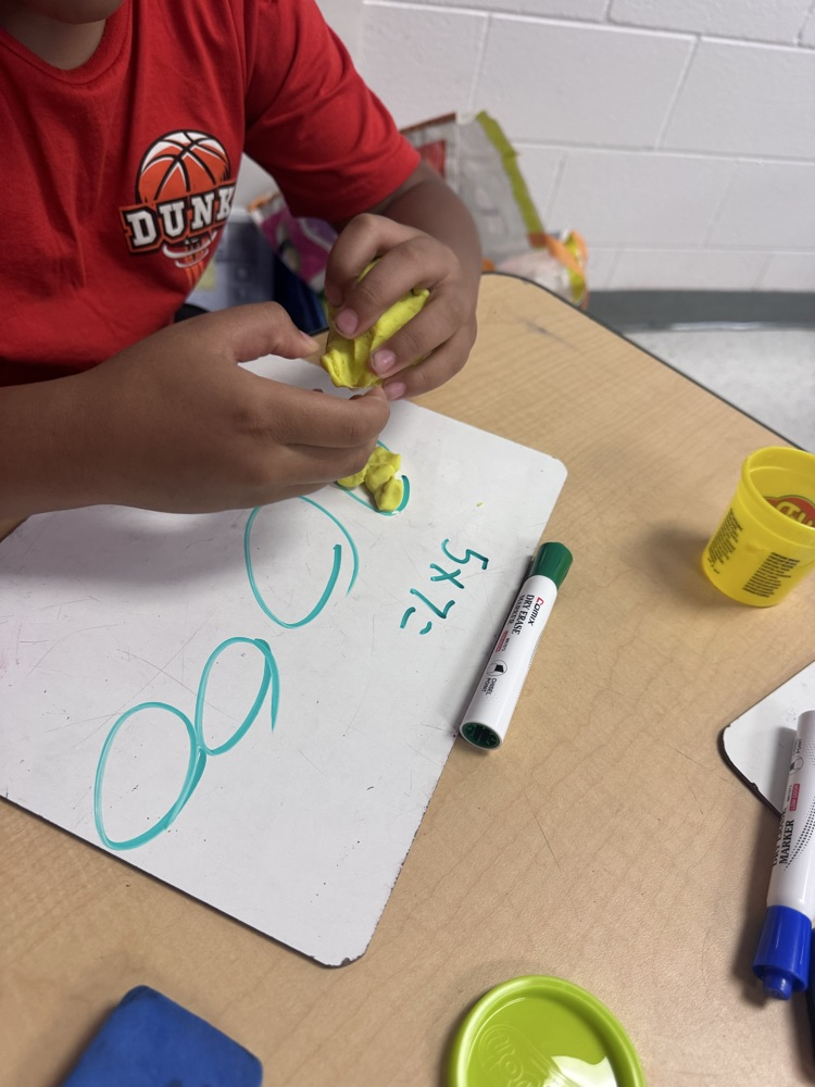 Students use colorful Play-Doh on dry-erase boards to create arrays and equal groups while practicing multiplication facts.