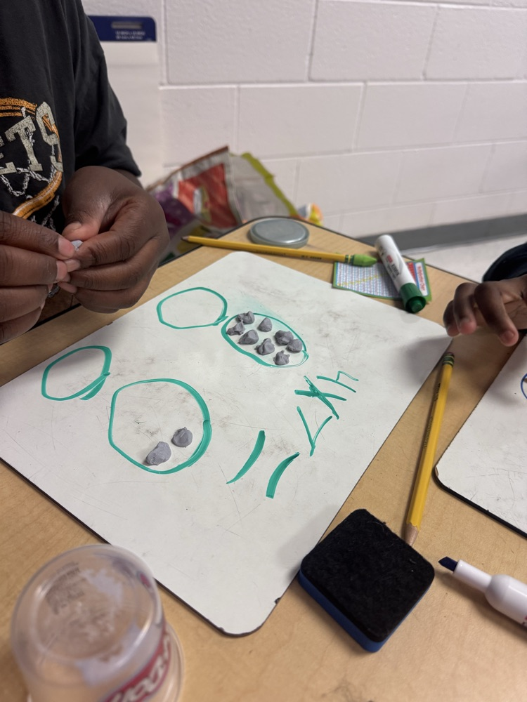 Students use colorful Play-Doh on dry-erase boards to create arrays and equal groups while practicing multiplication facts.