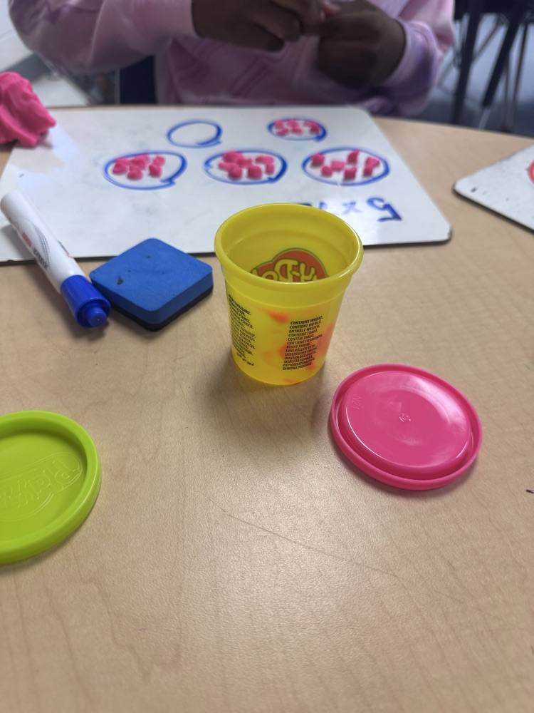 Students use colorful Play-Doh on dry-erase boards to create arrays and equal groups while practicing multiplication facts.