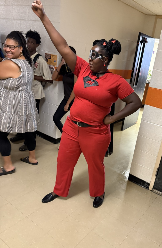 Teacher posing like a superhero in hallway
