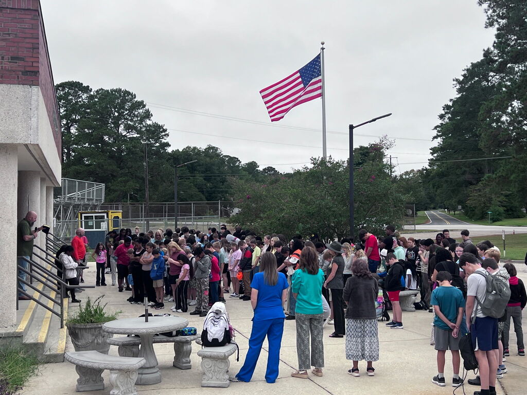 Students praying around the flag pole