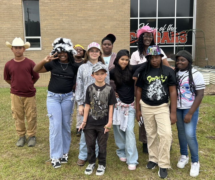 Teacher and students outside of school standing together  smiling for a picture