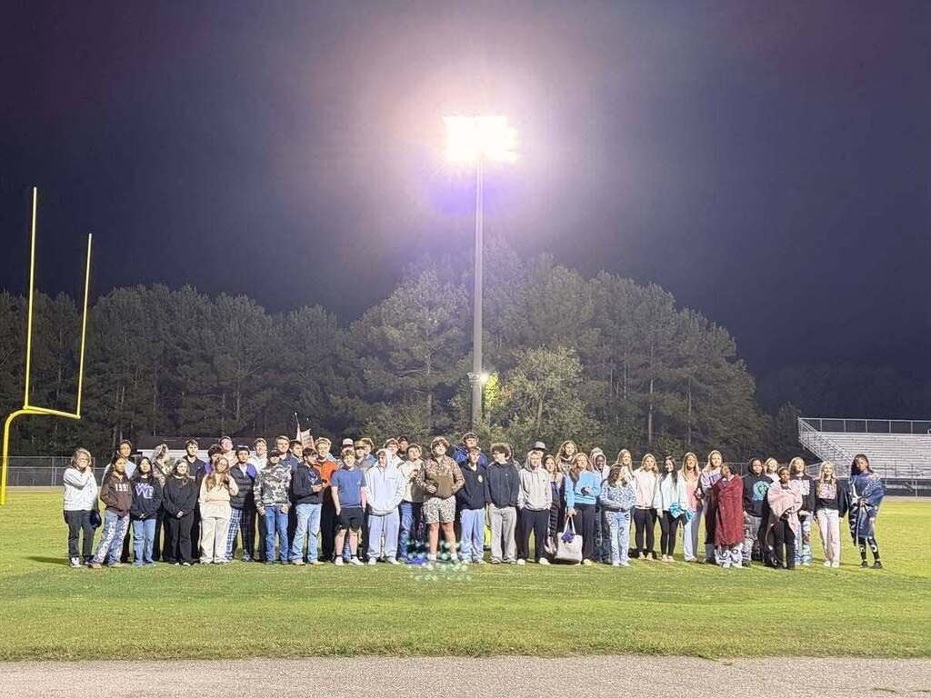 High school seniors gather together on a football field early in the morning under stadium lights for Senior Sunrise