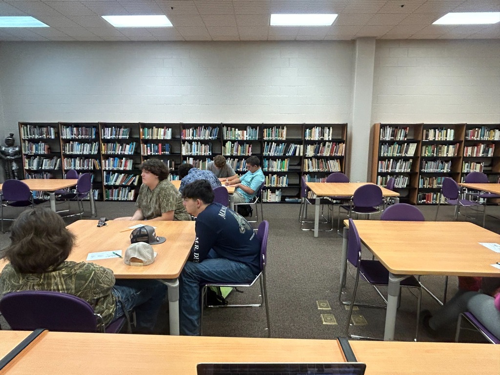 Students sit and talk at tables in the school media center during the WyoTech information session.