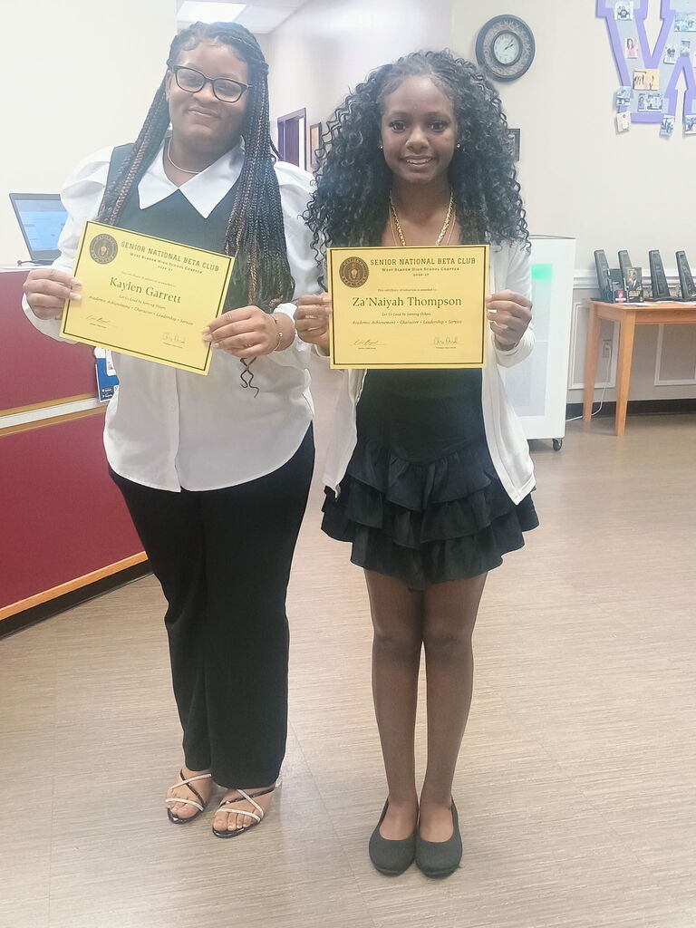 Two young ladies holding certificates. 