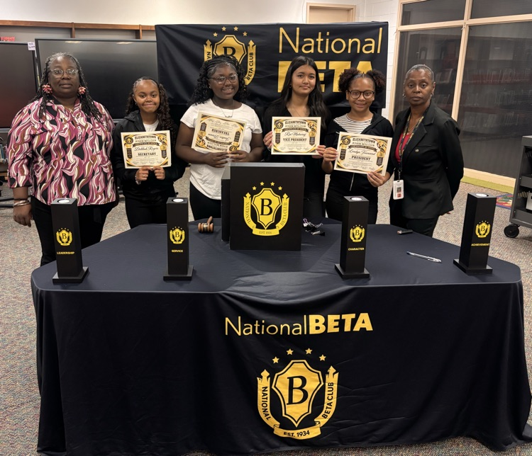 Students and sponsors standing behind beta table holding certificates 