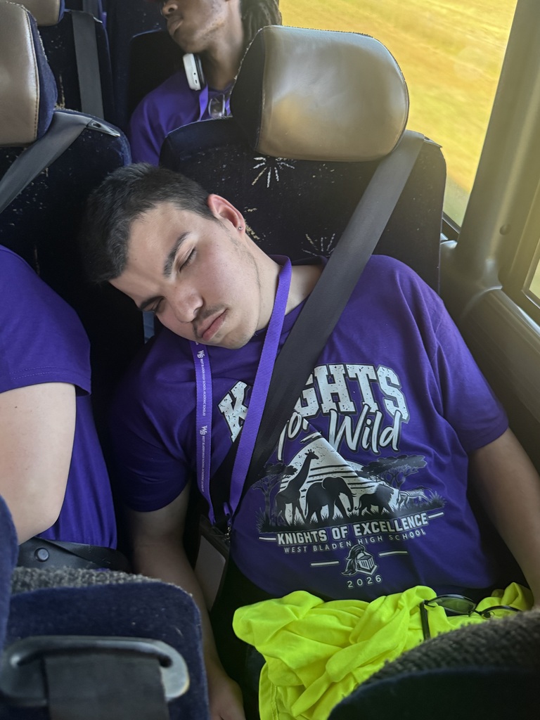 Male student in purple shirt asleep on the charter bus after a day at the zoo