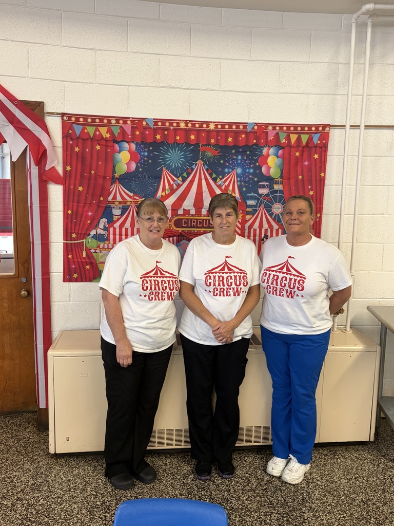 Cafeteria staff smiling wearing tshirts that say "circus crew".