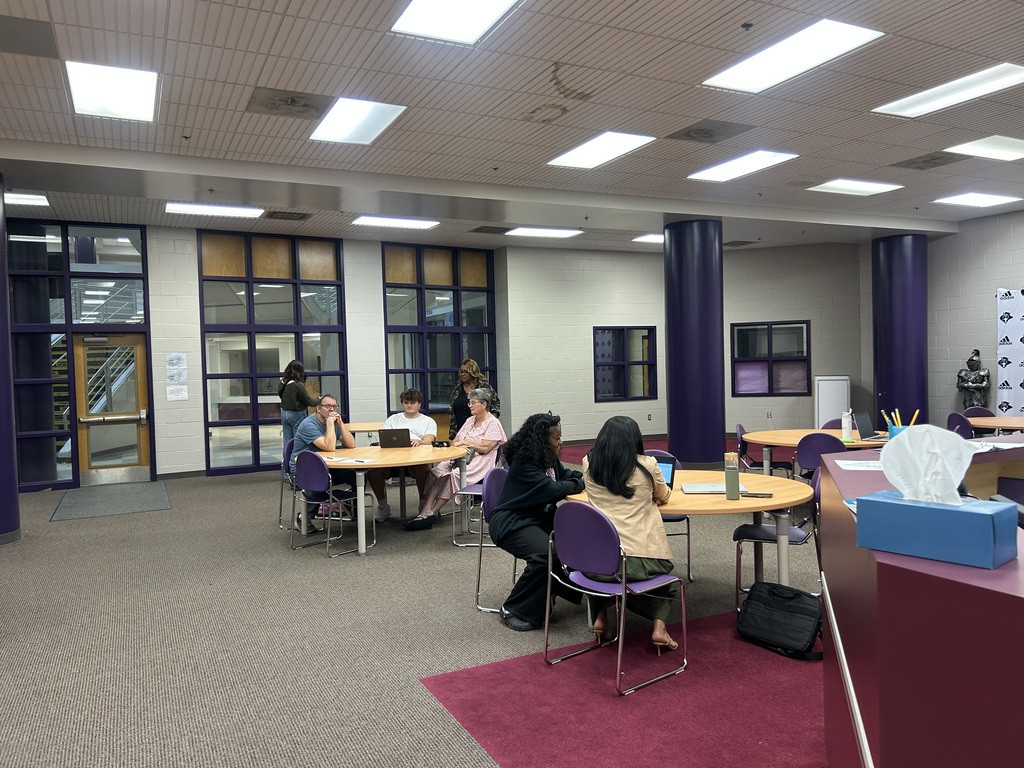 Students and families sit together at tables in West Bladen High School's atrium, working on college applications and financial aid paperwork during the College Application + FAFSA Workshop.