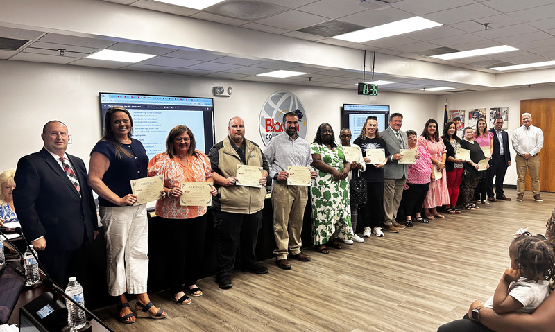 Beta Sponsors and Principals stand with the superintendent and board chair to be recognized.