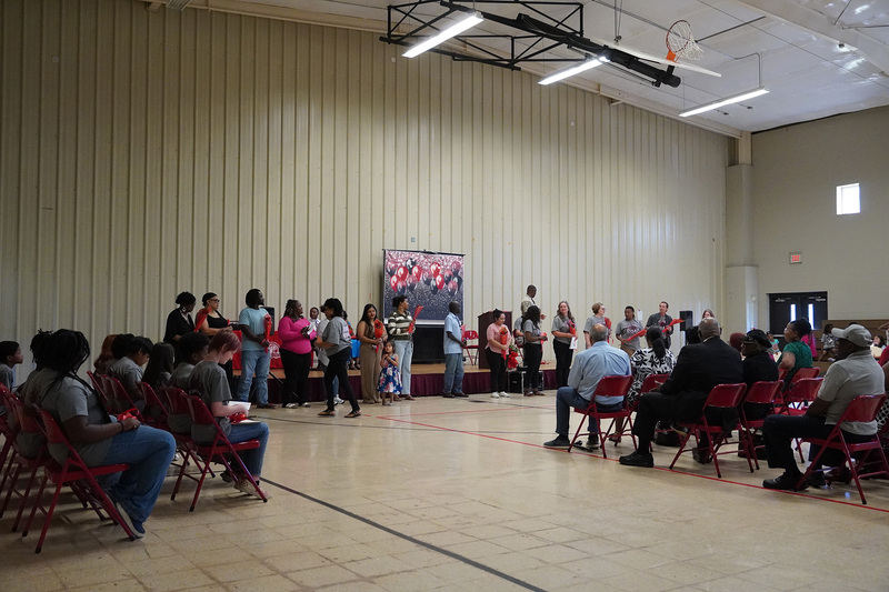 5th grade parents stand at the front of the room, to be recognized for their part in helping there students have a successful academic career thus far.