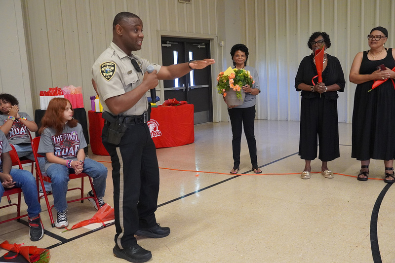 The SRO who is emceeing the event stands talking to students and parents.