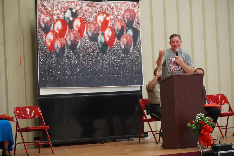 The principal of East Arcadia School is on stage, standing at the podium making remarks
