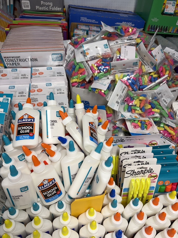 Stacks of glue, erasers, and constructionpaper.