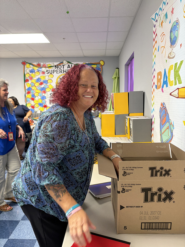 An adult boxing up donated school supplies.