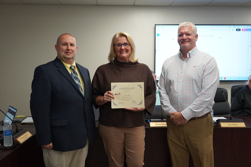 woman stands between two gentleman 