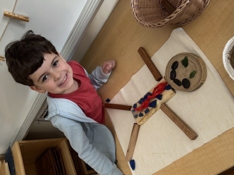 Young child creating a person with loose parts.
