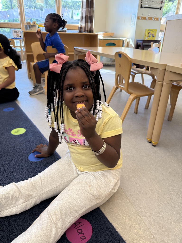 Girl sitting on floor eating a piece of cantelope