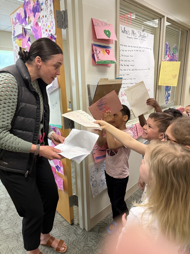 A gorup of young hcildren handing cards to adult.