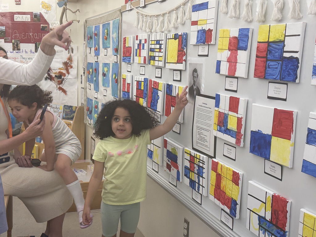 Student pointing to her "Mondrian" inspired art  work.