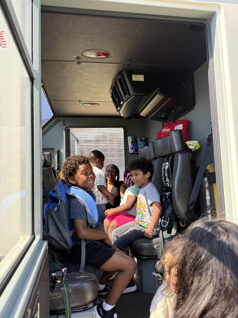 Several young children inside a fire engine.