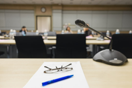 Microphone on a table with a blurred image of of a board room in the background