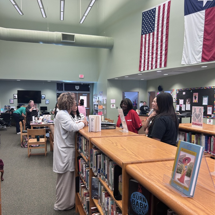 teachers look at books in the library 