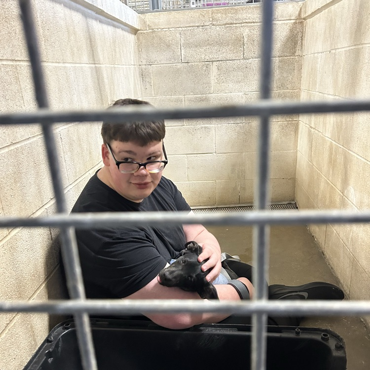 student sitting and posing with a dog