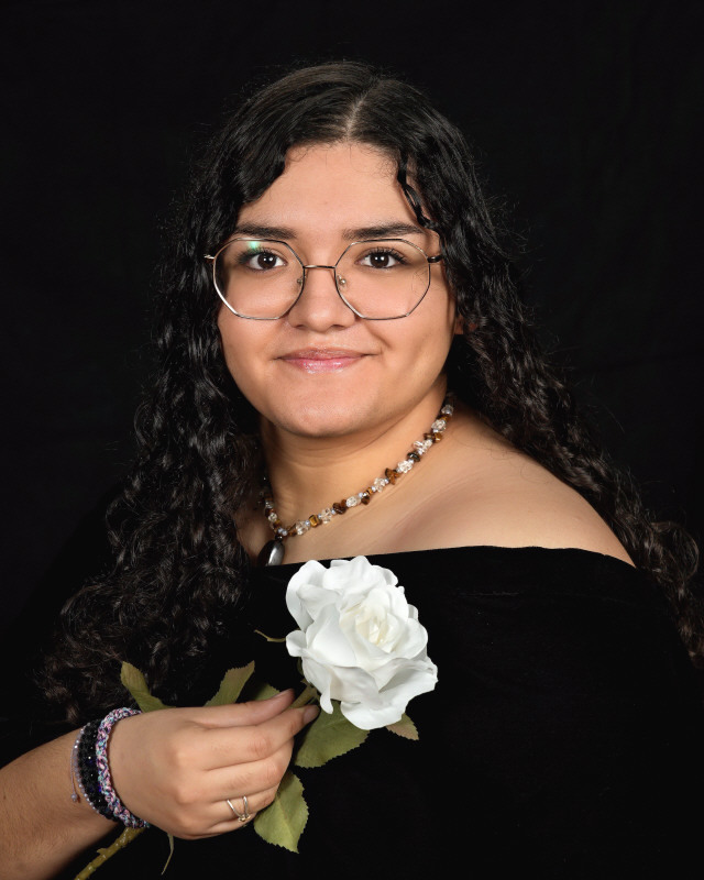 graduate poses with white rose