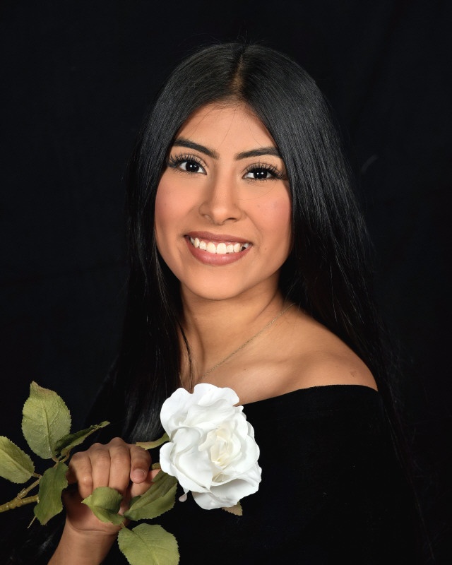 graduate posing with white rose