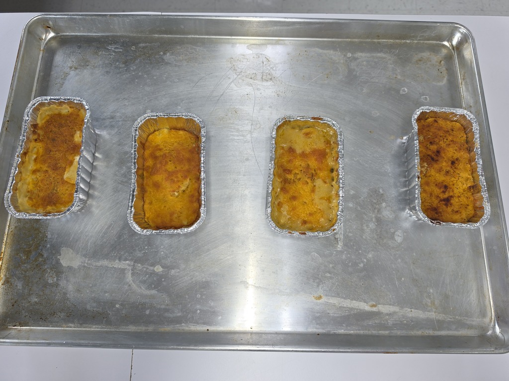 Four small aluminum pans of baked mac and cheese