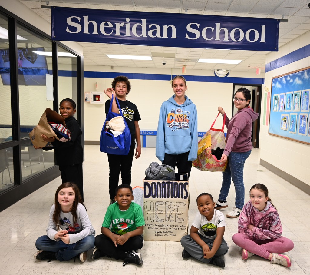 Kylie with sheridan students and donations
