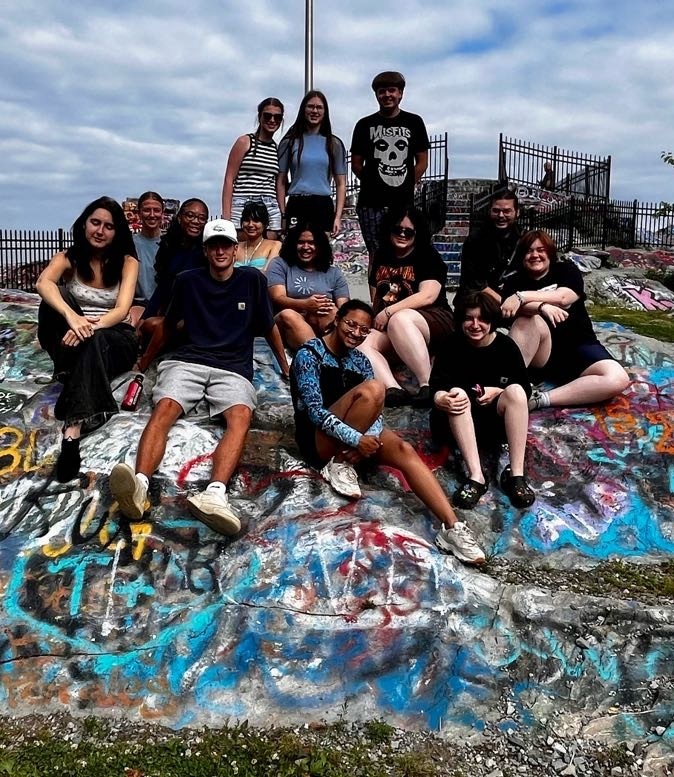 A group of students gathered on a rock for a photo.