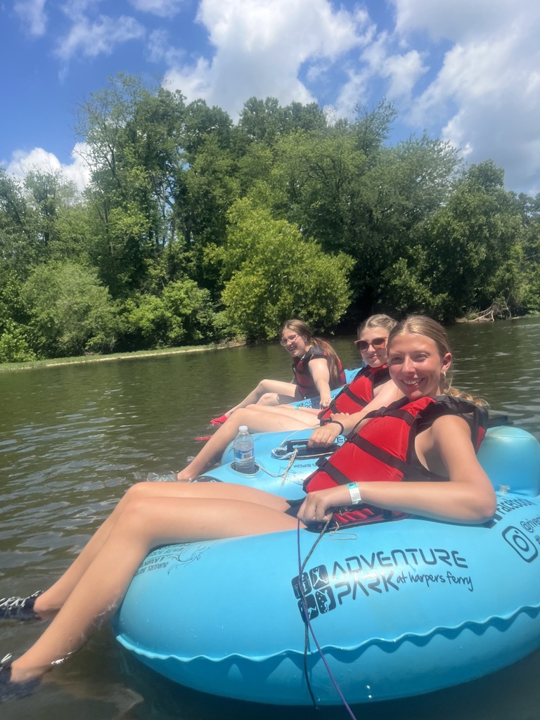 Students floating down a river on a raft.