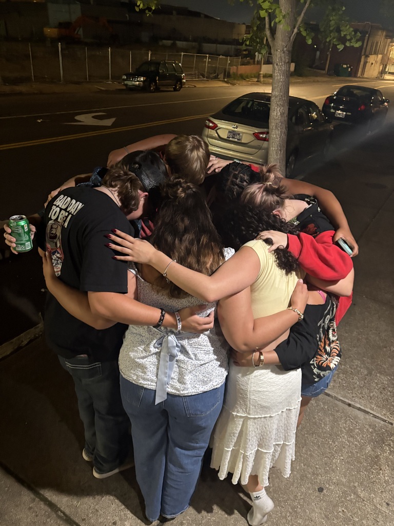 A group of students hugging before they are getting ready to leave after a fun week.