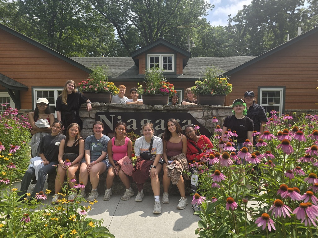 Students sitting in front of a sign at Niagara Cave