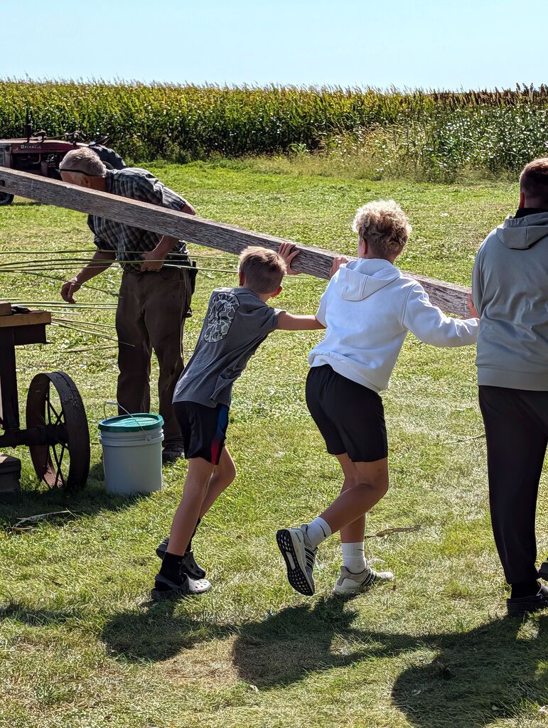 Students pushing a wood beam