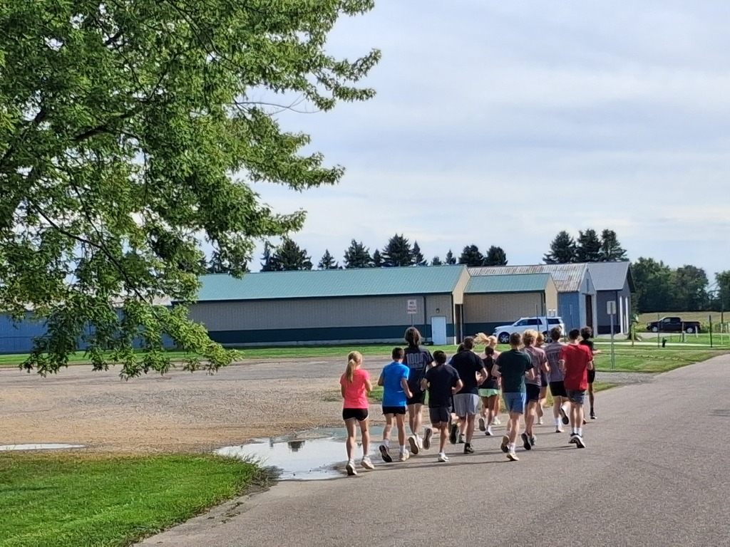 Cross Country team runs the football to Wilson Field