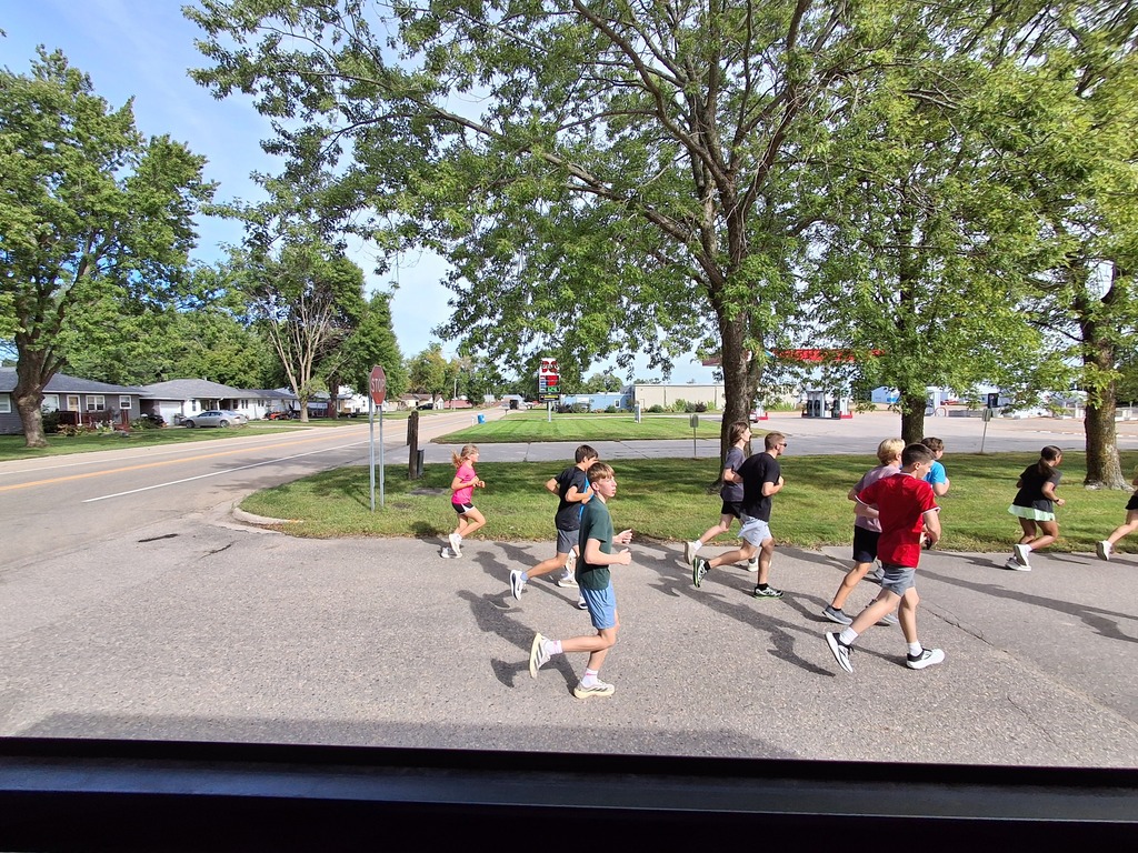 Cross Country team runs the football to Wilson Field